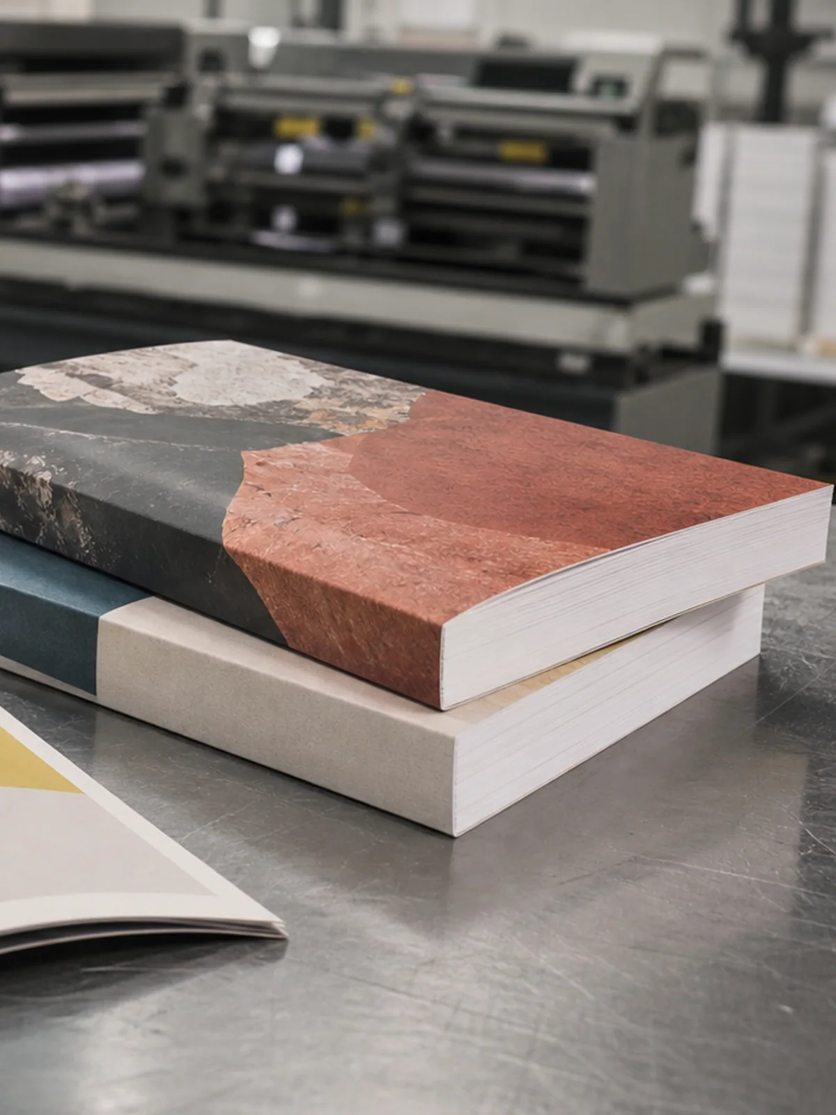 Revistas grampeadas e livros encadernados em uma mesa de inspeção gráfica